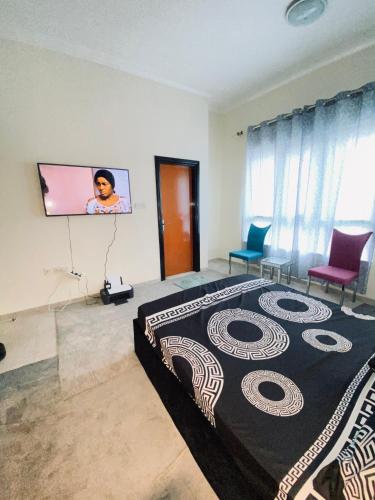 a bedroom with a large bed and a flat screen tv at Jovian guest house in Dubai