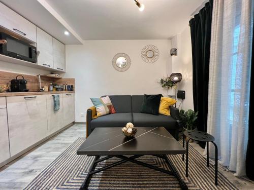 un salon avec un canapé et une table dans l'établissement La Cloche Dorée, parking, 3 étoiles, en plein cœur de Fontainebleau, à Fontainebleau