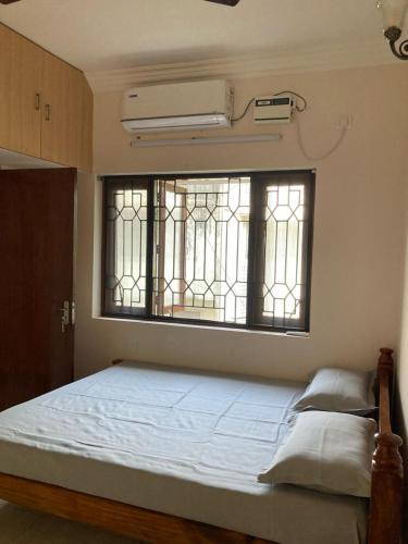 sypialnia z łóżkiem i oknem w obiekcie Teynampet Eldams Road w mieście Ćennaj