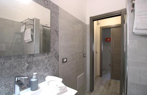 W łazience znajduje się umywalka i lustro. w obiekcie Capo d'Orlando Apartments - Doria 52 w mieście Capo dʼOrlando