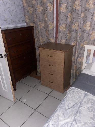 a bedroom with a wooden dresser and a bed at House Rooms & RV Rooms Near LAX in Los Angeles