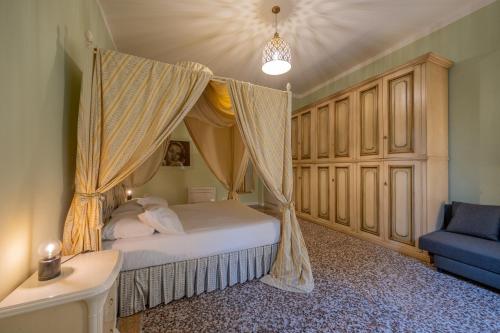 - une chambre avec un lit à baldaquin et un canapé bleu dans l'établissement Lungarno Buozzi 7 Apartments, à Pise