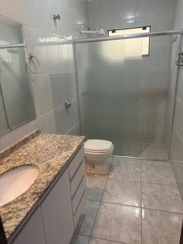 een badkamer met een douche, een toilet en een wastafel bij Casa da Denize in Cascavel