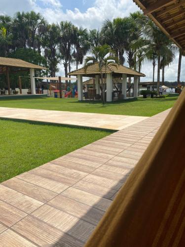 a walkway in a park with palm trees and a building at Lagoa do Cassó - Pousada Porto do Cajú in Caçozinho