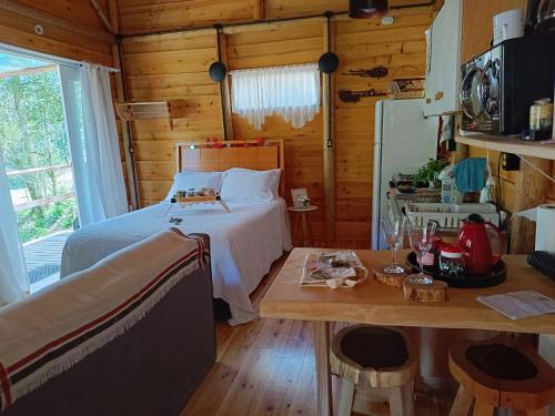 a bedroom with a bed and a table at Cabana hidromassagem Morada Alma Gêmea in Campo Alegre