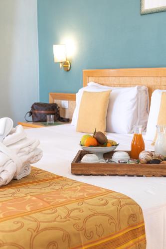 a hotel room with two beds and a tray of fruit at Hotel Belvedere San Gottardo by LVG Hotel Collection in Verbania