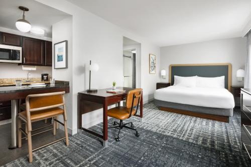 マンチェスターにあるHomewood Suites by Hilton Manchester/Airportのベッドとデスクが備わるホテルルームです。