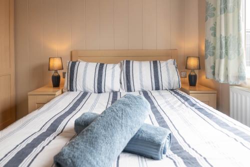 een slaapkamer met een bed met blauwe kussens erop bij 6 Atlantic Crescent in Ilfracombe