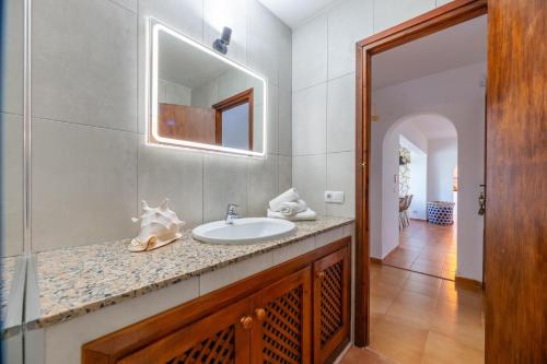 een badkamer met een wastafel en een spiegel bij Bonaire, villa up to 8+2 with pool & views in Ibiza-stad