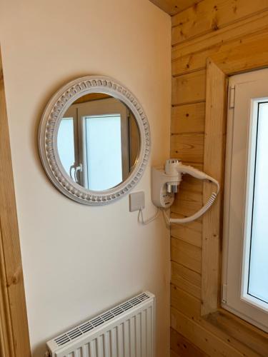um espelho na parede de um quarto com um radiador em Glenariff Forest Larch Cabin em Glenariff