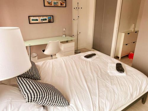 een slaapkamer met een wit bed en een bureau bij DUPLEX - TERRASSE 2 CHAMBRES CENTRE-VILLE JAUDE in Clermont-Ferrand