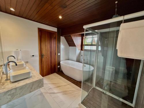カンポス・ド・ジョルドンにあるCasa Três Rios - Campos do Jordãoのバスタブと洗面台のあるバスルーム