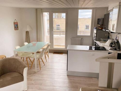 een keuken en een woonkamer met een tafel en stoelen bij DUPLEX - TERRASSE 2 CHAMBRES CENTRE-VILLE JAUDE in Clermont-Ferrand