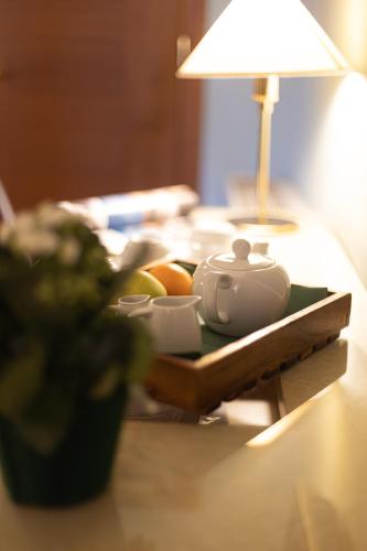 a table with a lamp and a tea set on it at Hotel Belvedere San Gottardo by LVG Hotel Collection in Verbania