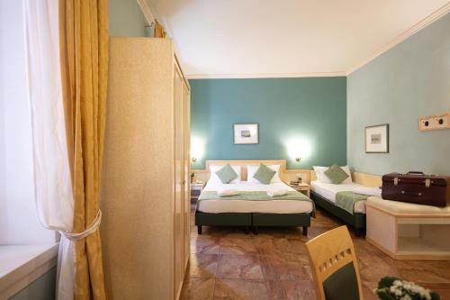 a bedroom with two beds and a door to a room at Hotel Belvedere San Gottardo by LVG Hotel Collection in Verbania