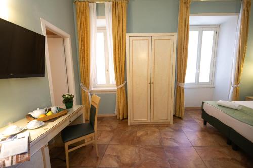 a small room with a desk and a bed and a room with a deskicter at Hotel Belvedere San Gottardo by LVG Hotel Collection in Verbania