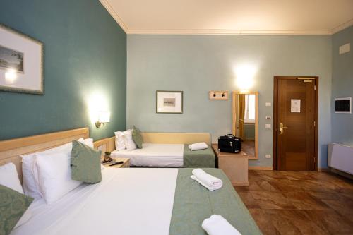 a hotel room with two beds and a couch at Hotel Belvedere San Gottardo by LVG Hotel Collection in Verbania