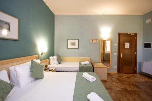 a hotel room with two beds and a couch at Hotel Belvedere San Gottardo by LVG Hotel Collection in Verbania