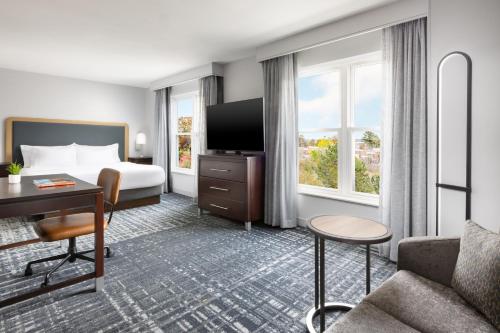a hotel room with a bed and a desk at Homewood Suites by Hilton Manchester/Airport in Manchester