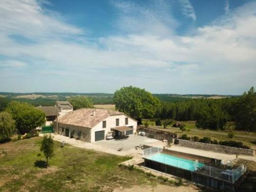eine Luftansicht eines Hauses mit Pool in der Unterkunft Villa de 6 chambres avec piscine privee jardin amenage et wifi a Montpezat de Quercy in Montpezat-de-Quercy