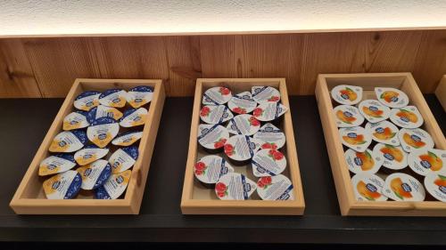 four wooden boxes filled with different types of sushi at Residence Altea in Ortisei