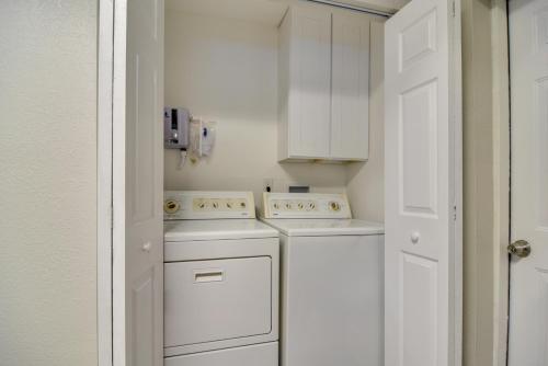 a kitchen with white appliances and a white door at Ideally Located Palm Harbor Condo Walk Downtown! in Palm Harbor