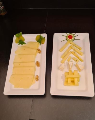 two white plates with cheese and grapes on them at Residence Altea in Ortisei