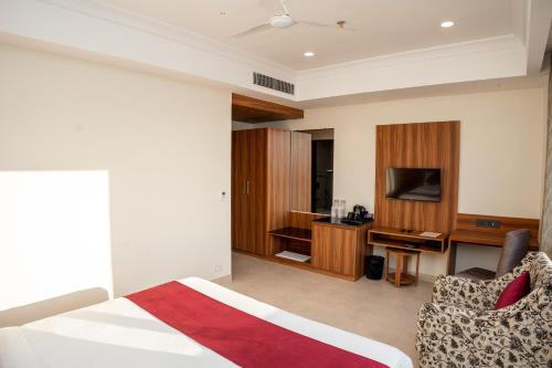 una camera d'albergo con un letto e una televisione di Raghunandan Palace - A Premier Boutique Stay, City Center & 500 Meters from City Railway Station a Udaipur