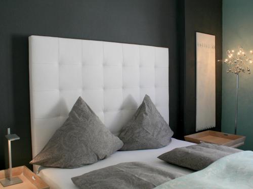 una camera con un letto bianco con due cuscini di Ferienwohnung Luxus & Lifestyle a Lindau