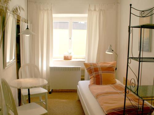 Zimmer mit einem Bett, einem Tisch und einem Fenster in der Unterkunft Ferienwohnung Altes Haus 2 in Lindau
