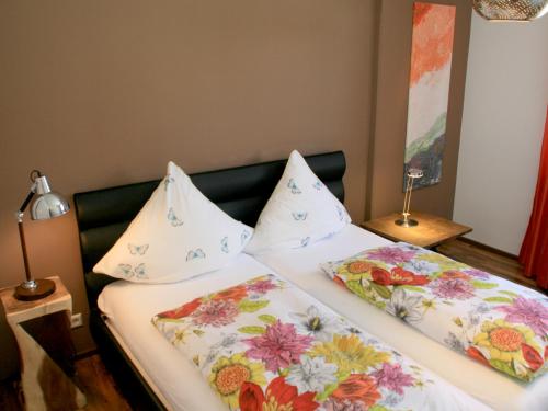 um quarto com 2 camas e almofadas florais em Ferienwohnung Belle Etage em Lindau