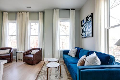 a blue couch in a living room with windows at Vetro Guest House in Richmond