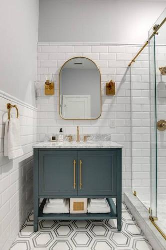 a bathroom with a blue cabinet and a mirror at Vetro Guest House in Richmond
