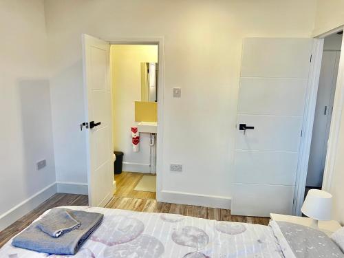 a white bedroom with a bed and a bathroom at Lux en-suite Manchester City - Center - COOP Arena in Manchester
