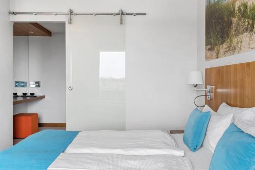 a bedroom with a bed with blue and white pillows at Best Western Plus Park Globetrotter Copenhagen Airport in Copenhagen