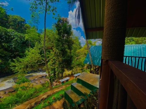 a porch with a view of a river and trees at The Rainforest Hideaway in Deniyaya