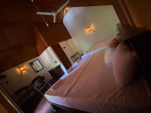 a bedroom with a bed and a chair in a room at The Rainforest Hideaway in Deniyaya