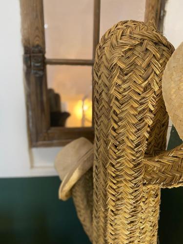 une chaise en osier dans une chambre avec fenêtre dans l'établissement La Mansio, à LʼIsle-sur-la-Sorgue