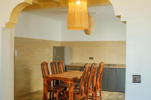 a kitchen with a wooden table and chairs at Dar Iziki in Sidi Kaouki