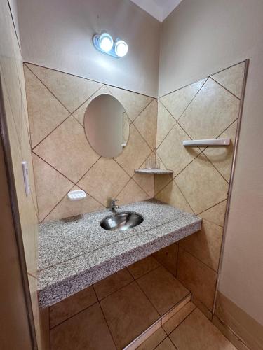 W łazience znajduje się umywalka i lustro. w obiekcie Hotel Valle Colorado w mieście Villa Unión
