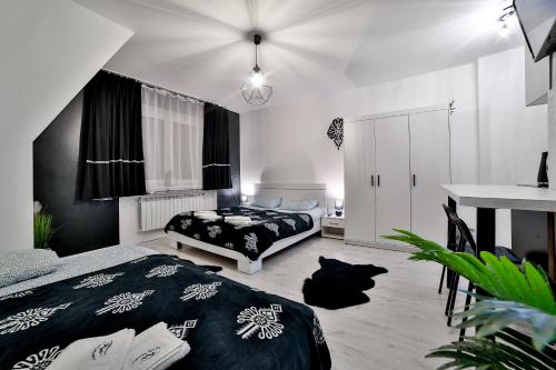 a bedroom with two beds and a desk in it at Apartamenty czarna perła in Szaflary