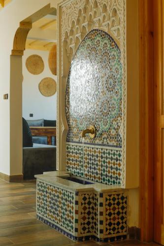 a fountain in the middle of a room at Dar Iziki in Sidi Kaouki
