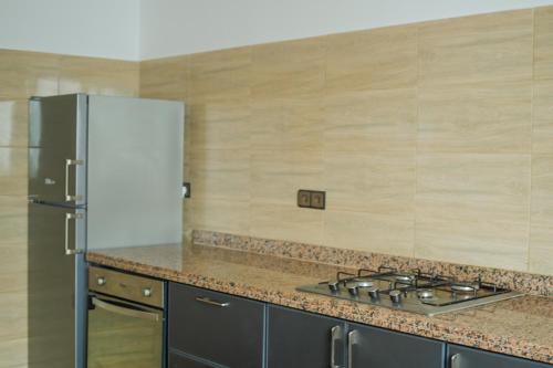 a kitchen with a stove and a refrigerator at Dar Iziki in Sidi Kaouki