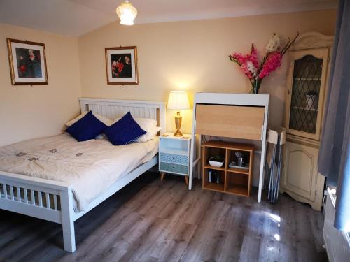 Impeccable 1-Bed Lodge in Eastleigh في إيستلي: غرفة نوم بسرير و إناء من الزهور