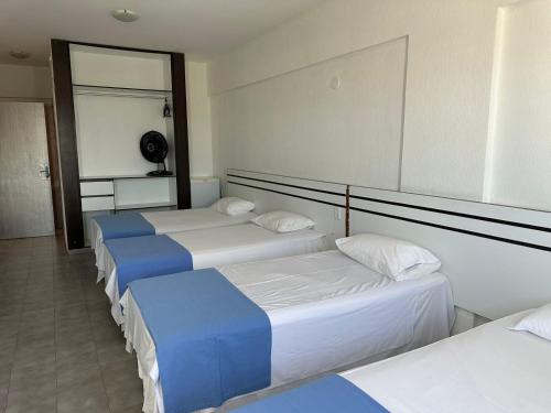 a row of four beds in a room at VILLA DEL SOL Hotel in Fortaleza