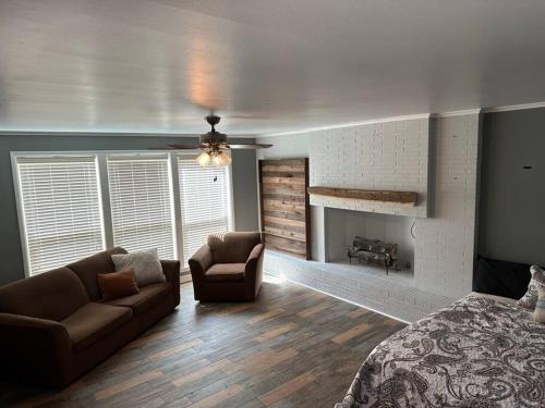 ein Schlafzimmer mit einem Bett, einem Sofa und einem Kamin in der Unterkunft Warhawks Cavern Getaway ( Near ULM ) in Monroe