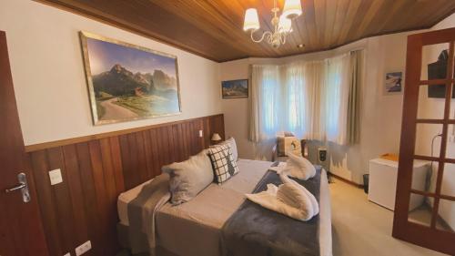 una camera da letto con un letto con cuscini sopra di Village de France Araucárias a Campos do Jordão