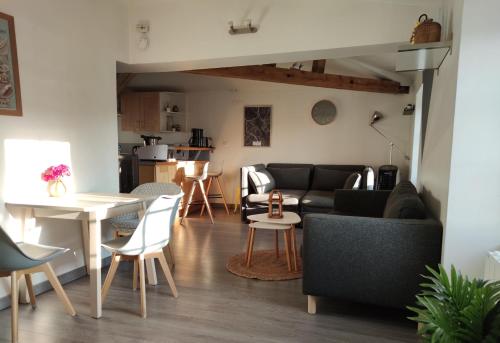 a living room with a couch and a table at Escale à Clisson - La Parenthèse in Clisson