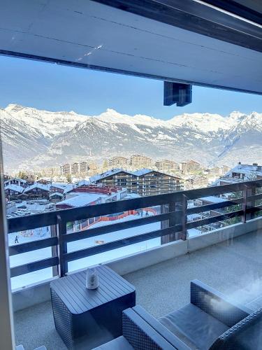 a balcony with a view of a city and mountains at Haute-Nendaz - Ski-in/ski-out - Le Mont-Fort in Nendaz