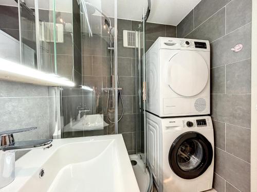 a bathroom with a washing machine next to a sink at Haute-Nendaz - Ski-in/ski-out - Le Mont-Fort in Nendaz